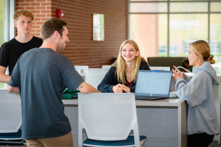 Admissions Couselor speaking to three other students