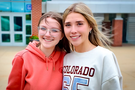 Two girls posing for a photo in front of the Student Activity Center