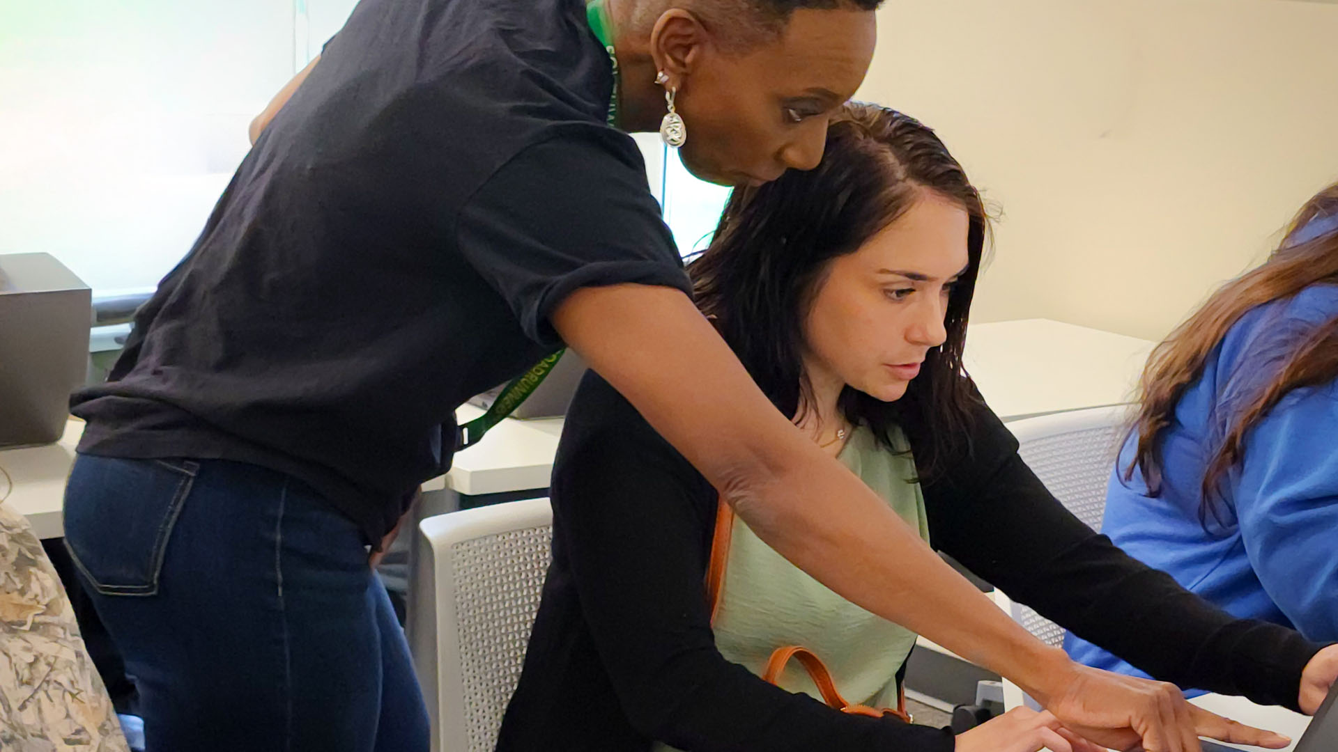 Advisor sitting with a student and showing them a brochure about a program