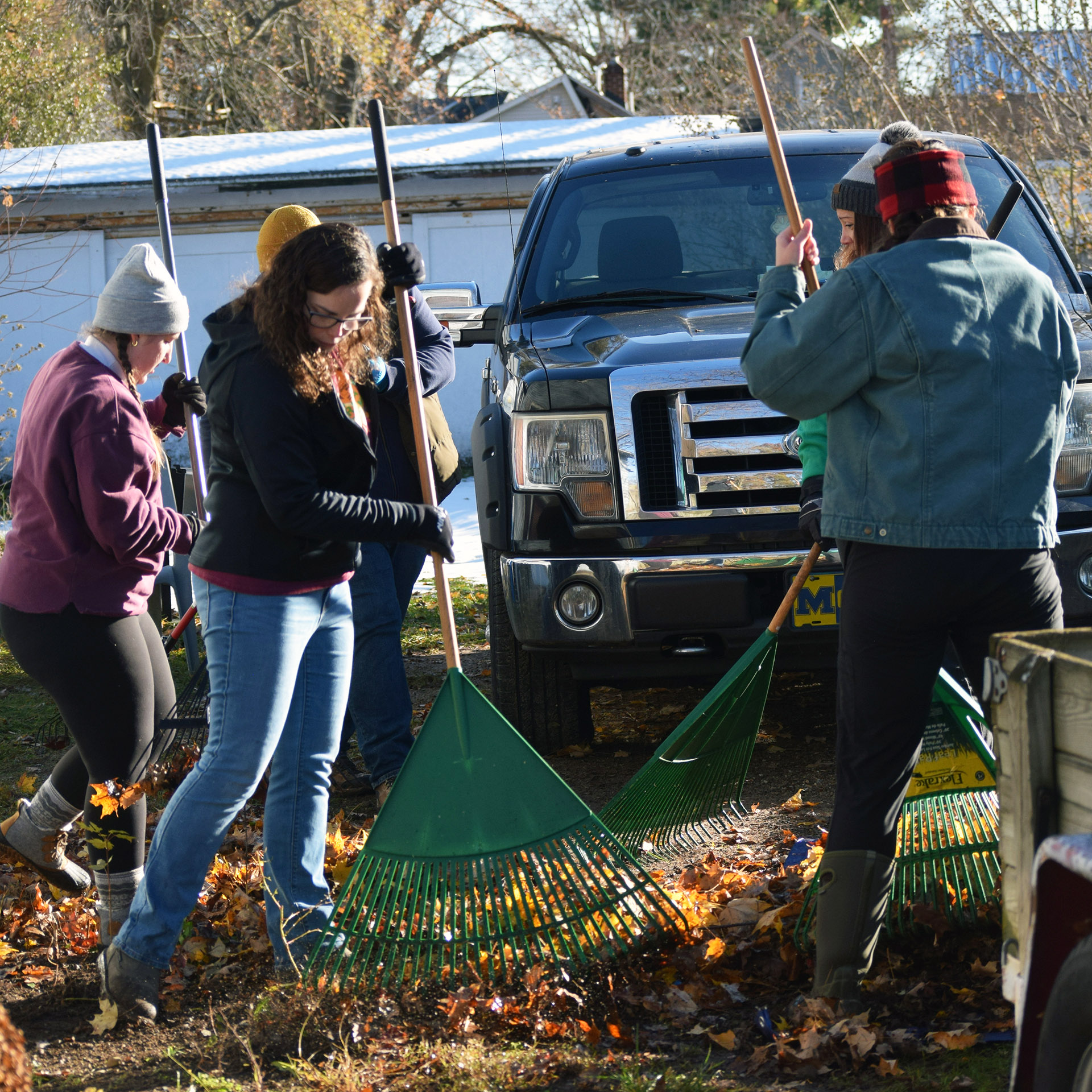 Staff members rake on James Street in Dowagiac